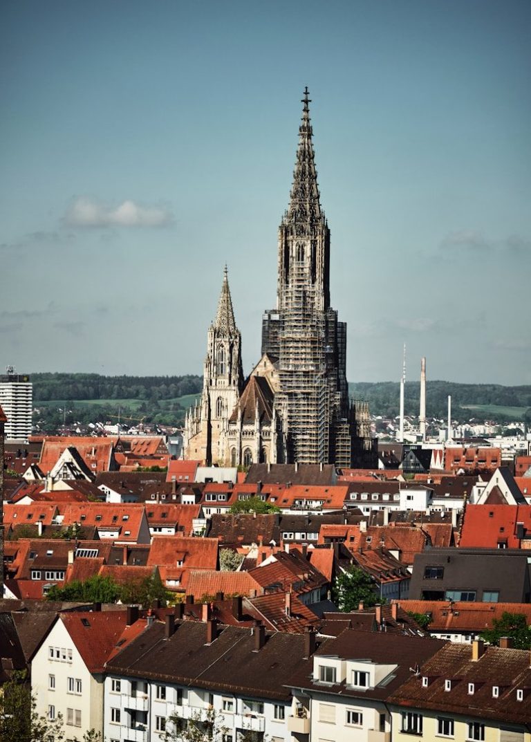 Der Ulmer Münster mit seinem hohen Turm über einer Stadt mit roten Dächern.